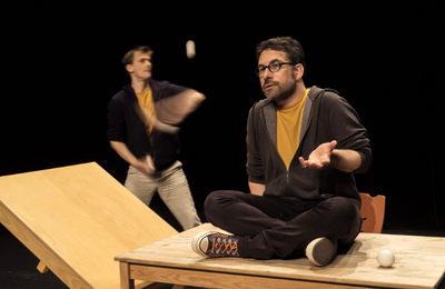 Photo du spectacle L'envers de nos décors de Clément Dazin et Thomas Scotto. Deux hommes sont sur des tables en pin avec des boules de jonglages.