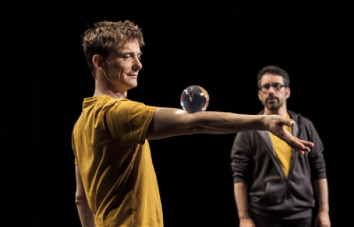 Photo du spectacle L'envers de nos décors de Clément Dazin et Thomas Scotto. Deux hommes sont sur des tables en pin avec des boules de jonglages.